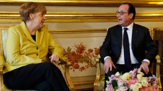Merkel und Hollande sitzen nebeneinander