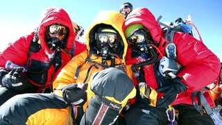 Drei in modernste Bekleidung gehüllte Bergsteiger auf dem Mount Everest.