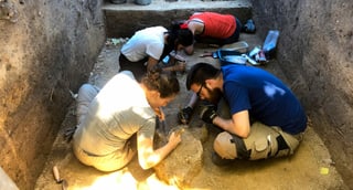 Archäologen arbeiten in einem Graben