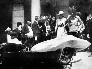 Schwarzweissfoto: Franz Ferdinand in Uniform steigt mmit seiner Frau in ein Auto.