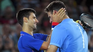 Novak Djokovic umarmt Juan Martin Del Potro am Netz innig.