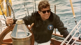 JFK sitzt an Bord der US Coast Guard Yacht Manitou bei der Küste von Maine.