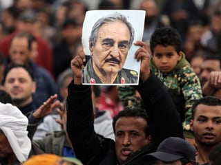 Mann hält Transparent mit Bild von Militärkommandant Kahlifa Haftar in die Luft, Benghazi, 17.12.17 Mann hält Transparent mit Bild von Militärkommandant Kahlifa Haftar in die Luft, Benghazi, 17.12.17
