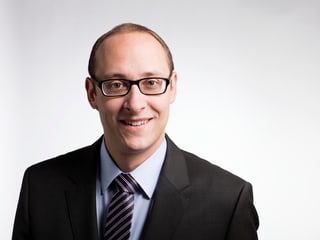 Martin Candinas mit gestreifter Krawatte und Brille. Martin Candinas mit gestreifter Krawatte und Brille.