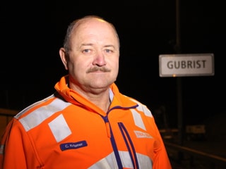 Der Einsatzleiter posiert in oranger Jacke vor dem Tunnelportal.
