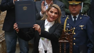Jeanine Áñez zeigt ein Gesetz in die Kamera