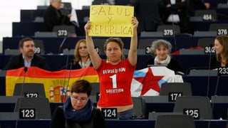Eleonera Forenza hält im EU-Parlament ein Schild hoch.