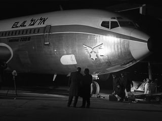 Fotografen machen Fotos eines stehenden Flugzeuges mit Einschusslöchern
