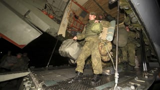 Russische Marine-Soldaten gehen von Bord eines Flugzeuges