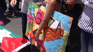 Ein Mädchen hält ein gemaltes Plakat mit der Auffschrift «Gaza» unter dem Arm.