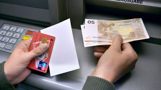 Ein Kunde nimmt Euro aus dem Bancomat
