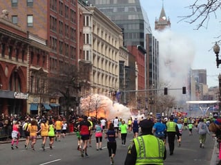 Menschen rennnen - im Hintergrund sieht man Feuer.