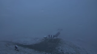 Verschneiter Berghang mit Skiliftbergstation.