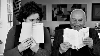 Tochter und Vater – Nora und Eugen Gomringer im Jahr 2013 verstecken sich lachend hinter Büchern