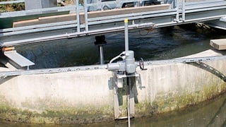 Blick auf Wirbelkraftwerk, Betonrondelle mit Wasser und Brücke darüber