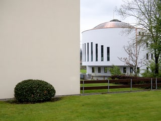 Ein weisses Gebäude mit schlitzartigen Fenstern und einer Kuppel. Ein weisses Gebäude mit schlitzartigen Fenstern und einer Kuppel.
