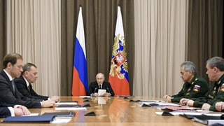 Putin an einem Sitzungstisch mit Uniformierten
