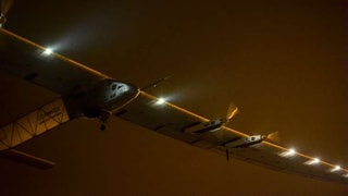 Solar Impulse 2 beim Abheben vor dem Nachthimmel.