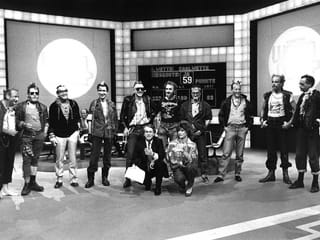 Frank Elstner mit einer Wettkandidatin. Auf der Bühne stehen 10 als Punks verkleidete Banker.