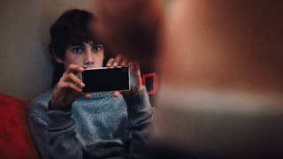 Ein Junge filmt mit dem Handy eine junge Frau.