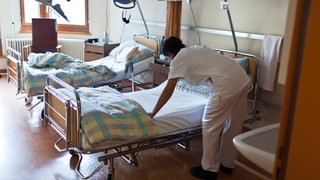 Spitalangestellte macht ein Spitalbett zu recht, auch ein zweites bett ist ohne Patientin oder Patent.