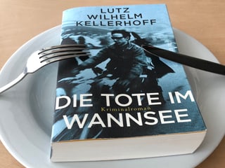 «Die Tote im Wannsee» liegt auf einem weissen Teller, Messer und Gabel seitlich an den Teller gestellt