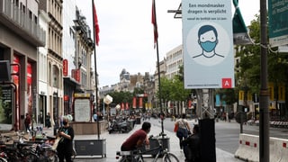 Ein Schild auf einem Platz in Antwerpen weist auf die erweiterte Maskenpflicht hin.