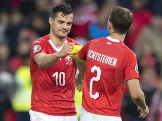 Xhaka gibt dem ausgewechselten Lichtsteiner nach Spielschluss die Captainbinde zurück. Xhaka gibt dem ausgewechselten Lichtsteiner nach Spielschluss die Captainbinde zurück.