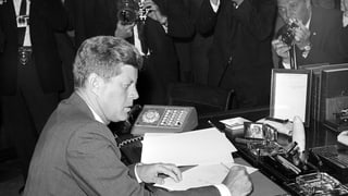 JFK an seinem Schreibtisch, kurz nachdem er die Proklamation betreffend Kuba Krise unterschrieben hatte. JFK an seinem Schreibtisch, kurz nachdem er die Proklamation betreffend Kuba Krise unterschrieben hatte.