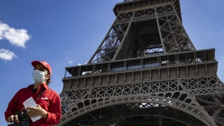 Ein Mensch vor dem Eiffelturm.