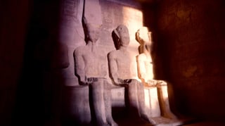 In Stein geschlagene Pharaofiguren werden von spärlichem Sonnenlicht beleuchtet In Stein geschlagene Pharaofiguren werden von spärlichem Sonnenlicht beleuchtet