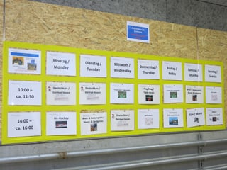 Zettel mit Beschäftigungsangeboten an der Wand.