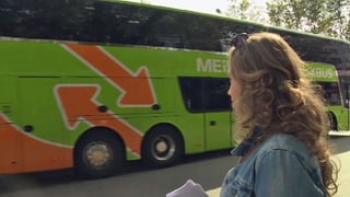 Eine Frau schaut einem Reisebus nach.