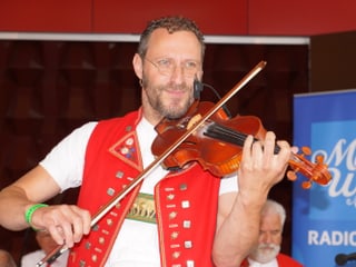 Ein Mann in Appenzellertracht spielt Geige.