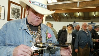 Angy Burri besichtigt eine Pistole, eine Colt Walker 1847.