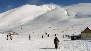Menschen im Schnee, schneebedeckte Hügel bis an den Horizont.