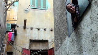 Menschen schauen aus Fenstern in einer Gasse des Bulaq-Viertels in Kairo