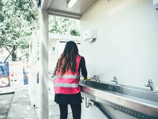 Asylsuchende schrubbt ein Lavabo am Openair Gampel. Asylsuchende schrubbt ein Lavabo am Openair Gampel.