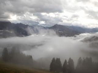 Unten liegt Nebel, dazwischen ist es hell, oben zeigen sich viele Wolken.