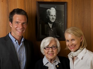 Patrick Kuster, Irène Truninger und Brigitte Kuster vor dem Bild der Gründerin Lina Schärer. 