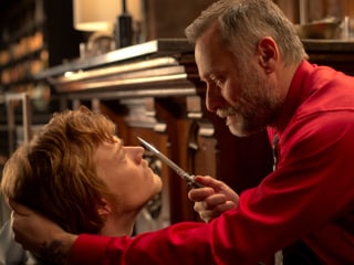 Der Boss der Russenmafia (Michael Nyqvist) bedroht mit einem Messer seinen Sohn (Alfie Allen).