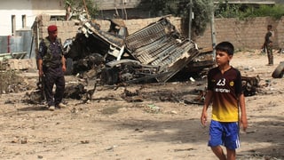 Ein Junge geht vorbei, wo kurz zuvor ein Motorrad-Bombe explodiert ist. 