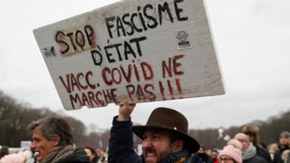 Ein Mann mit einem Schild in der Hand.