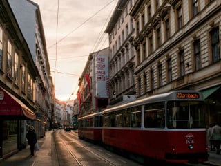 Eine Strasse mit einem Wiener Tram beim Sonnenuntergang.