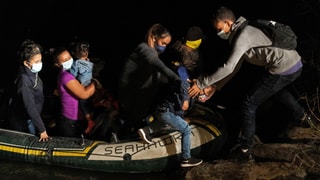 Migrantinnen kommen im Boot an Land in der Nacht