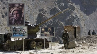Bilder von Achmed Schah Massud neben einem zerstörten Panzer.