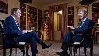 Obama und der Journalist sitzen einander gegenüber.