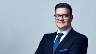 Ein junger Mann im blauen Anzug posiert mit verschränkten Armen. Ein junger Mann im blauen Anzug posiert mit verschränkten Armen.