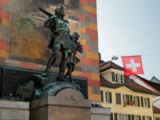 ein Denkmal eines Mannes mit Armbrust und eines Kindes ein Denkmal eines Mannes mit Armbrust und eines Kindes