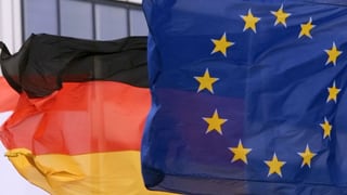 Deutsche und EU-Flagge wehen im Wind.
